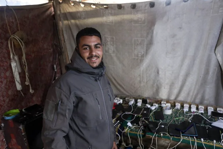 Gaza families survive in darkness, relying on drained phones for light.