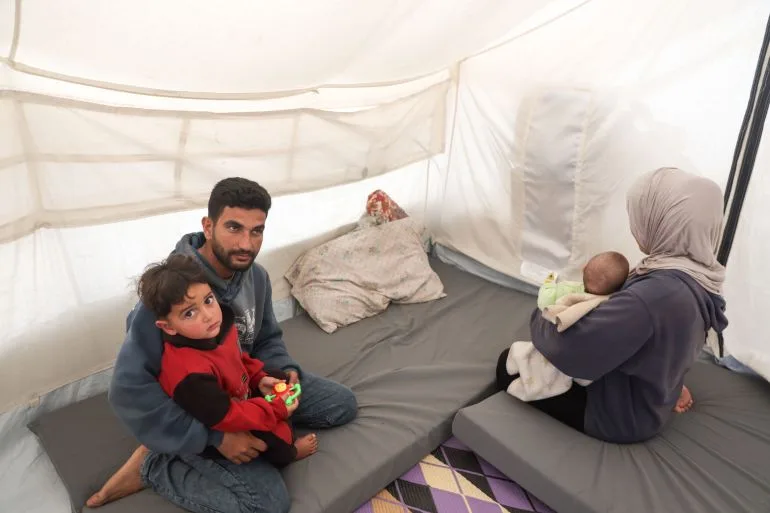 Gaza families survive in darkness, relying on drained phones for light.